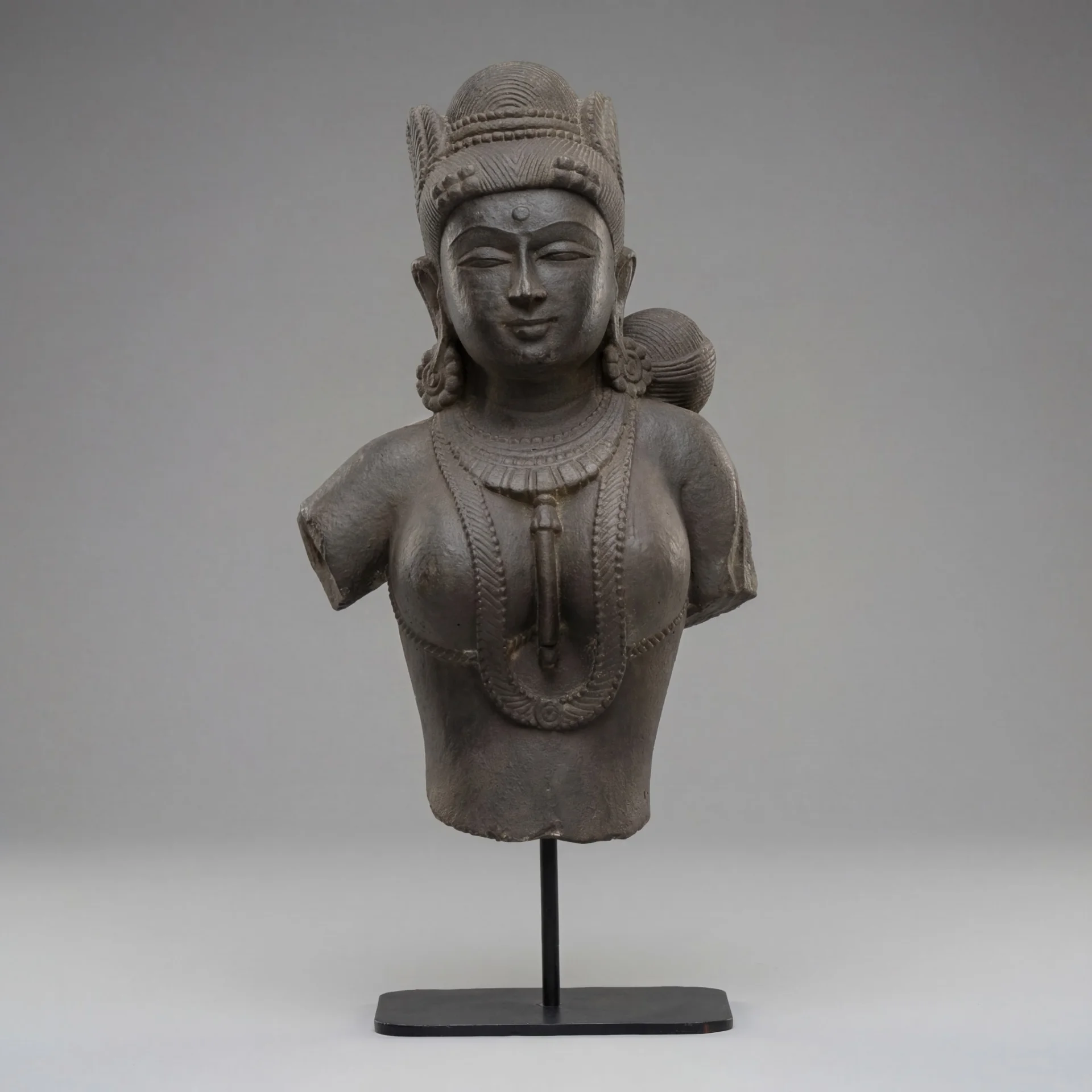 A front-view of the Female Figure Bust Sculpture, a stone composite replica showcasing intricate Chola style jewelry and craftsmanship.