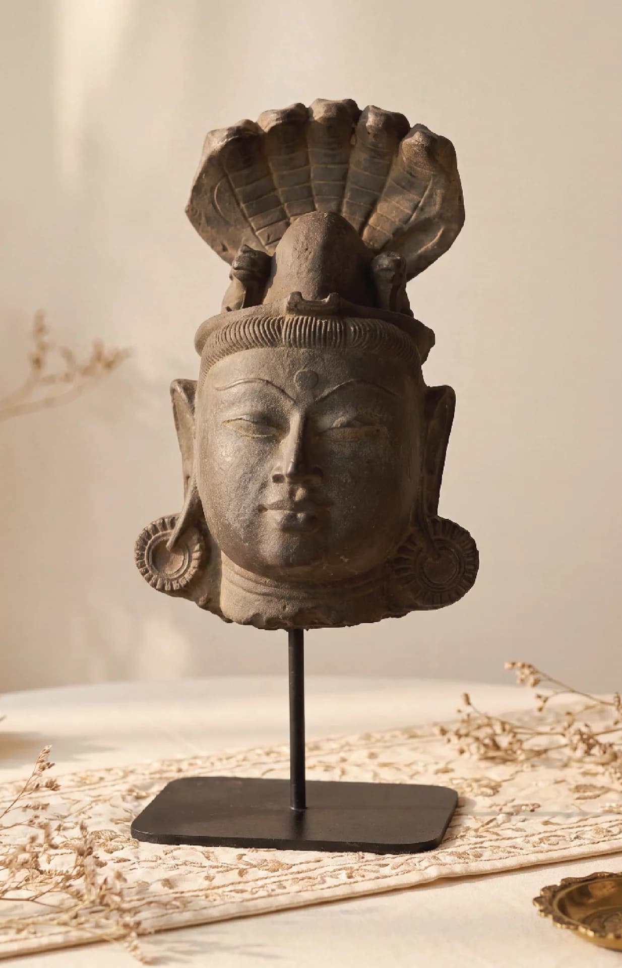 A front-facing view of the Shiva Lingam with Nandi & Serpent replica, featuring intricate stone-carved details on a stand.