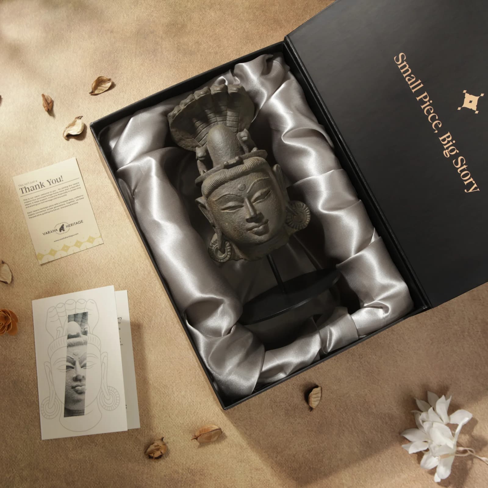 A Shiva Lingam with Nandi & Serpent stone composite replica rests inside a luxurious black gift box with satin lining.