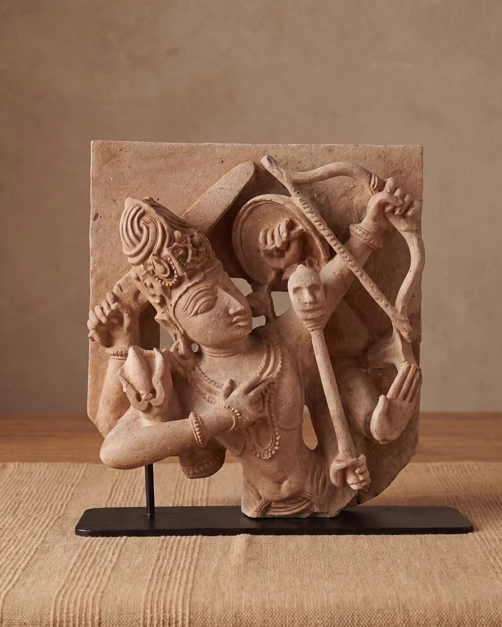 A front-facing view of the Tripurantaka Shiva stone composite sculpture, showcasing intricate relief carving of the deity holding a bow.
